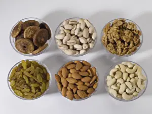 Dry fruits and nuts, almonds pistachios walnuts raisins figs cashew nuts in bowls