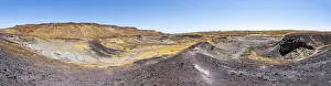 Dry landscape with yellow grass and black volcanic hills