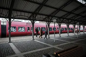 Dyrehaven Train station platform with passengers boarding a red train