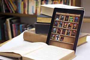 E-book reader beside a stack of old books, Germany