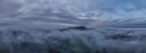 In the early morning, thick wafts of mist lie over the landscape