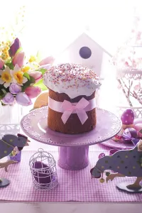 Easter cake and lilac desorations - wooden chicken and cock on the foreground