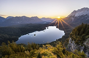 Eibsee lake at sunrise, sun shining over Bavarian alpine foothills