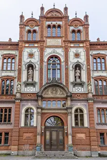 Elaborate red and white main building with sculptures and semicircular windows