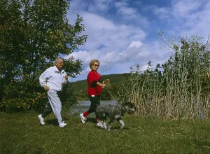 Elderly couple walking with dog