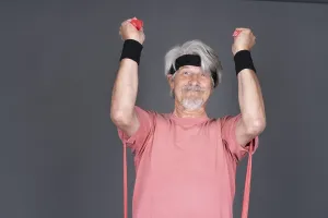 Elderly man with fitness outfit trains with fitness band