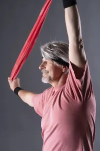 Elderly man with fitness outfit trains with fitness band