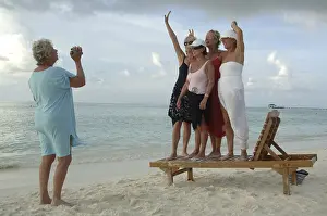Elderly women filming each other with a video camera on the beach