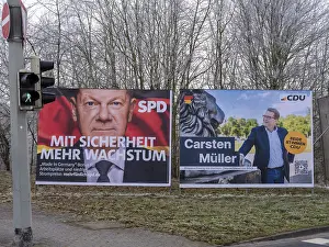 Election posters for the Bundestag election on 23 February 2025 behind a traffic light from the SPD with a portrait of