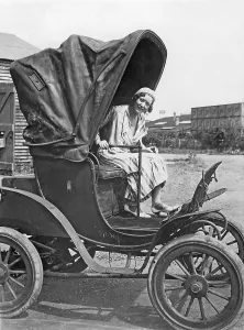 Electric cars in the 1930s. A woman sitting in the drivers seat in a electrical powered car