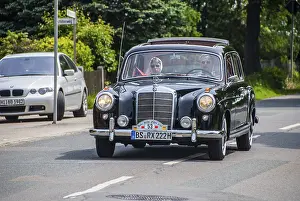 Elegant black Mercedes vintage car being driven on a quiet road