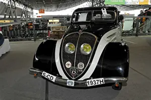 An elegant black vintage car from 1937 with chrome details and yellow headlights