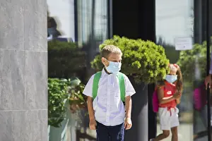 The elementary school student wearing a protective mask and backpack