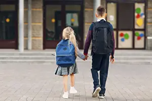Two elementary students brother and little sister going back to school