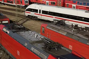 Elevated view of several local trains and an ICE train