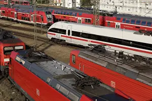 Elevated view of several local trains and an ICE train