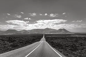 Empty endless country road through volcanic landscape