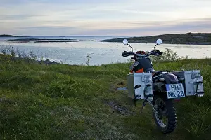 Enduro motorcycle on the Norwegian coast in the evening twilight