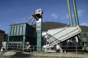 An engineer feeds coal into the hopper that fuels a boiler for a rendering plant