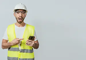 Engineer using and pointing at cellphone