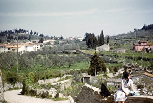 English tourist sitting on a wall in a village, Italy 1957