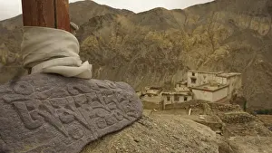An engraved Mani stone in a mountainous landscape