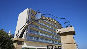 Entrance gate to the casino with ornate steel decorations in front of a modern building with balconies