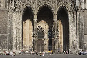 Entrance to Ulm Cathedral with people standing in front on Muensterplatz