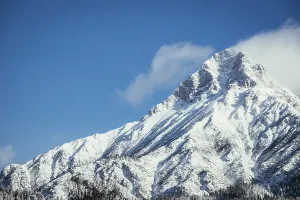 Epic snowy mountain peak with clouds in winter