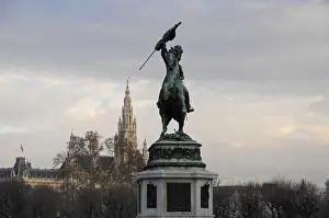 Equestrian statue in the foreground with historical architecture and sky in the background