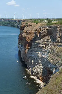 Erosion cliff with visible layers next to clear blue sea