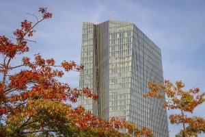 The European Central Bank (ECB) building in Frankfurt's Osthafen area stands out between autumnal colourful trees