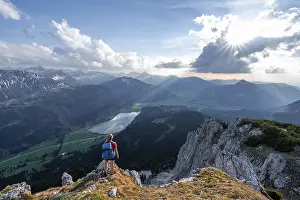 Evening atmosphere, mountaineer at the summit of Schartschrofen looking down on Haldensee