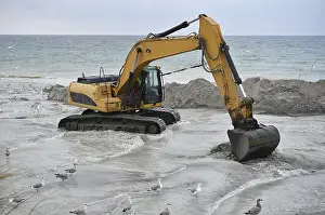 Excavators working to reclaim land on the beach of the DarB peninsula