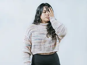 Exhausted young woman putting the palm on his face isolated