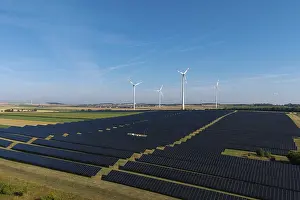 Extensive field with solar cells and wind turbines in rural area