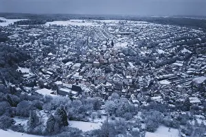 Extensive snow-covered urban area with forests and dense residential areas