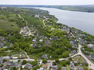 Extensive village view with many houses along a river and rolling hills