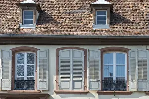Facade of an old house with shingle roof and shutters