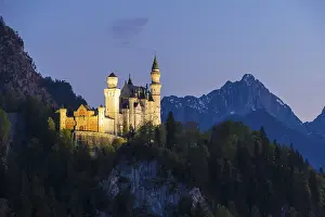 Fairytale castle in front of a tranquil and mysterious mountain landscape