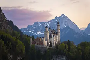 Fairytale Neuschwanstein Castle framed by the Alps after sunset