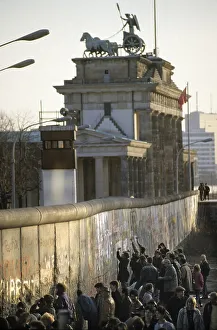 Fall of the Berlin Wall: people chiselling pieces off the Wall at the Brandenburg Gate (Mauerspecht)