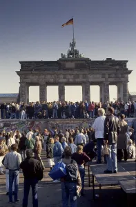 Fall of the Berlin Wall, people from East and West Berlin climbing on the Wall at the Brandenburg Gate