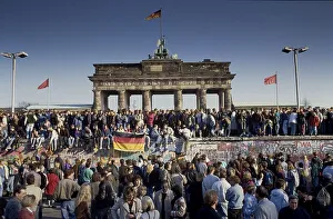 Fall of the Berlin Wall, people from East and West Berlin climbing on the Wall at the Brandenburg Gate