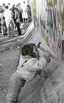 Fall of the Berlin Wall, young child using a hammer