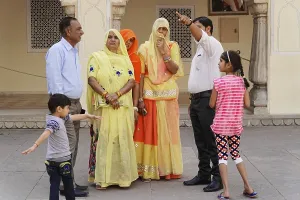 Family group in colourful traditional clothing during a conversation in the courtyard