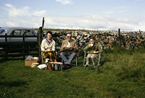 Family picnic in camping chairs in a field next to the car, Stumps Cross, North Yorkshire, England, 1963