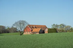 Farm at green field and blue sky in springtime in Ystad Municipality