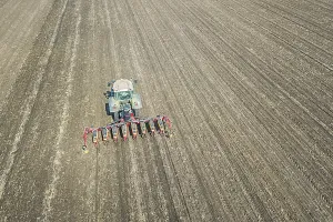 Farmer seeding crops at field. Seeding Aerial View