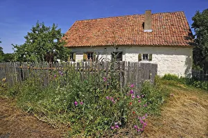Farmhouse, built in 1711, in front a farm garden with fence